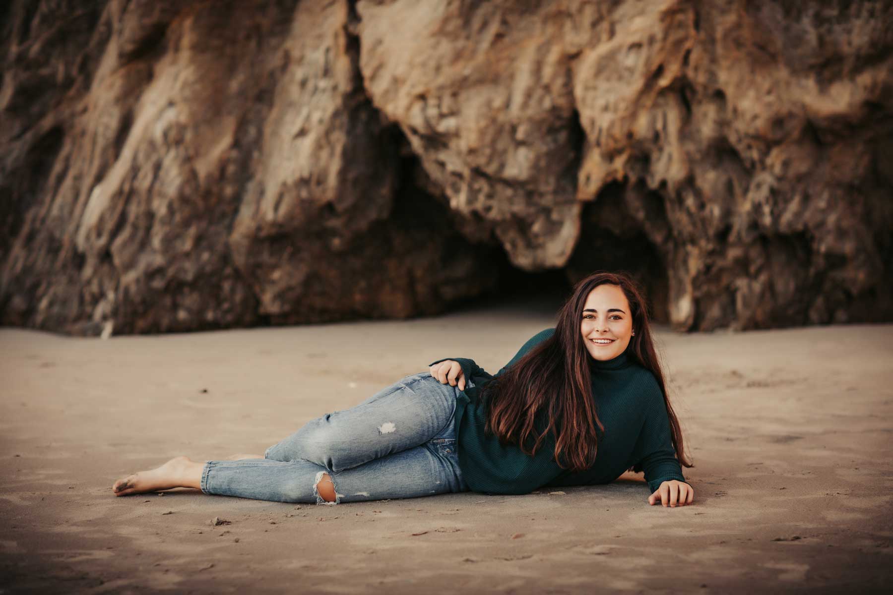 Girl on beach with jeans and sweater